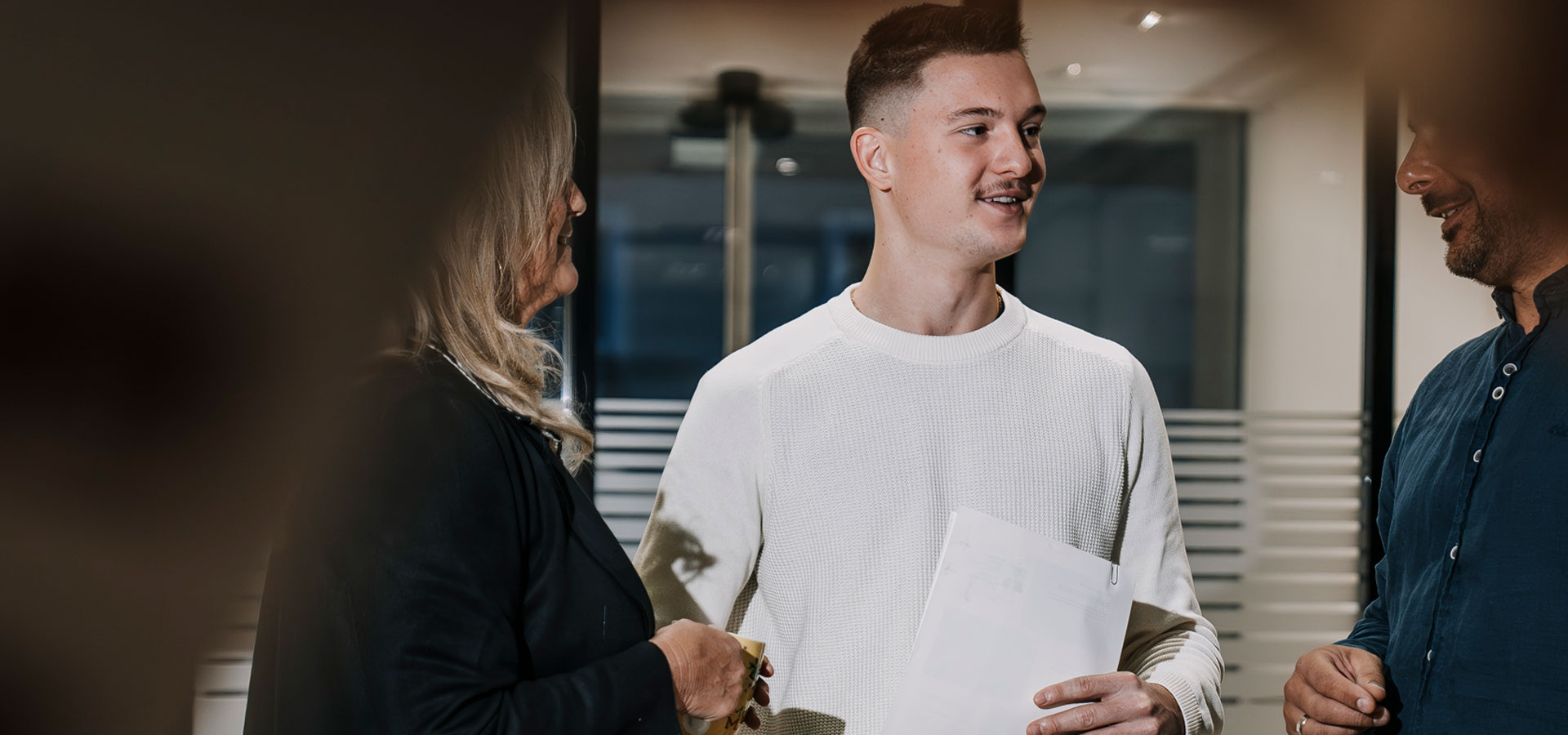 ein junger Mann unterhält sich mit anderen PErsonen