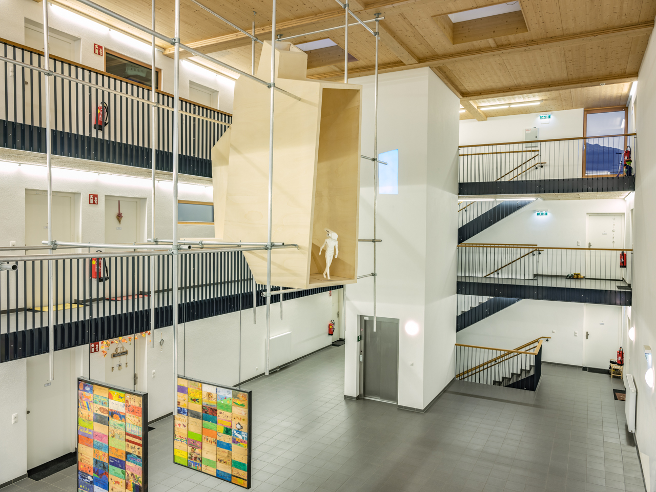 Kunst am Bau_Absam-Foehrenweg_Raum in Raum_weiße Skulptur in Holzkubus_Blick auf Stiegenhaus