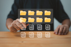 Am Schreibtisch, im Vorderrund virtuelle dokumentordner eingeblendet