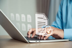 Am Laptop, Hände tippen am Laptop, virtuelles Dokument im Vordergrund